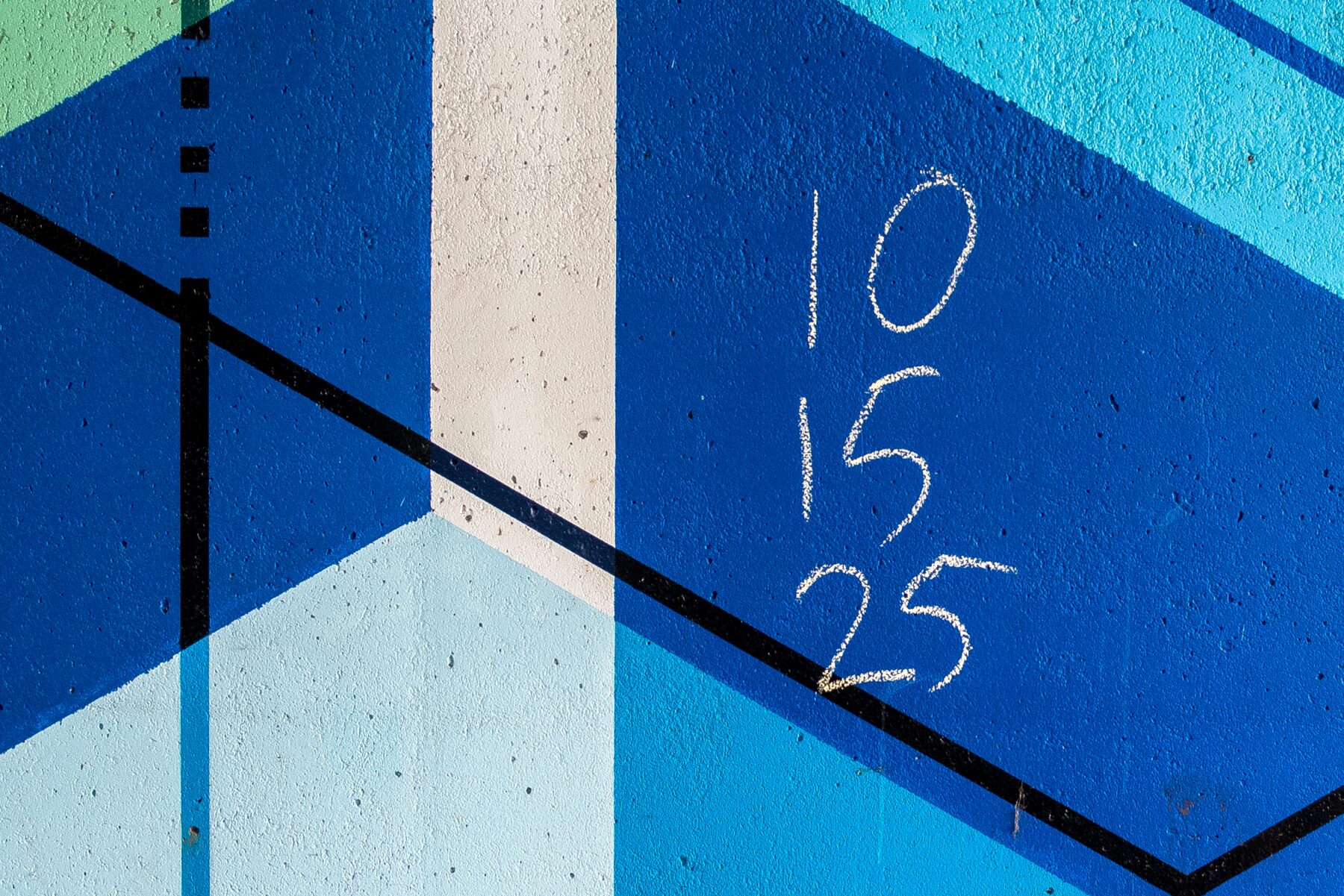 A blue background with a white stripe and three numbers written in chalk.